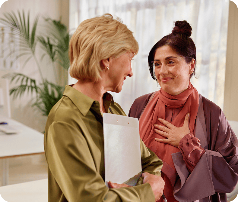 Fictional patient and caregiver smiling while talking about KISQALI® treatment for advanced breast cancer.