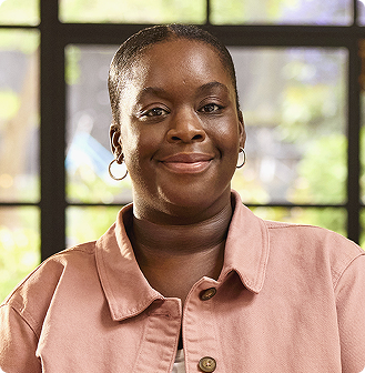 Portrait of a smilling black postmenopausal woman representing the MONALEESA-2 breast cancer study design.
